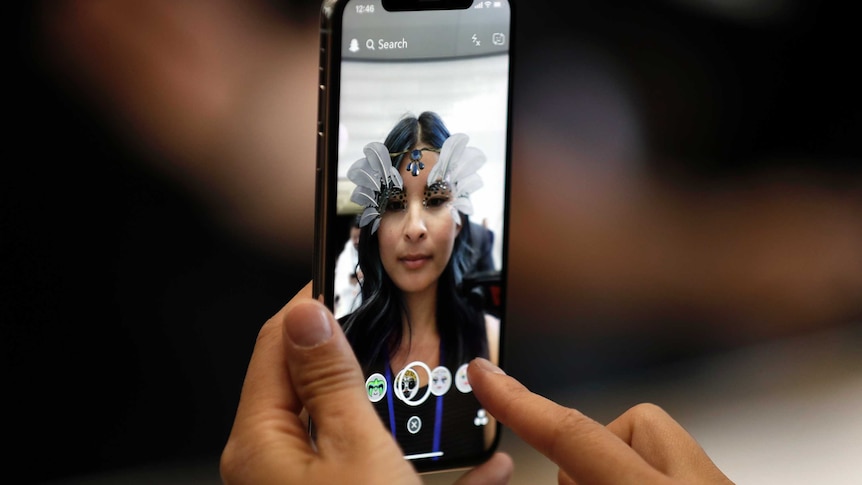 Woman tries out new iPhone X at Apple showcase
