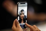 Woman tries out new iPhone X at Apple showcase