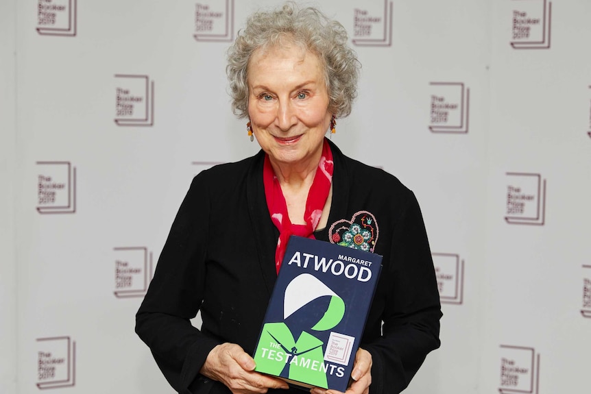 Margaret Atwood poses for a photo while holding her book The Testaments