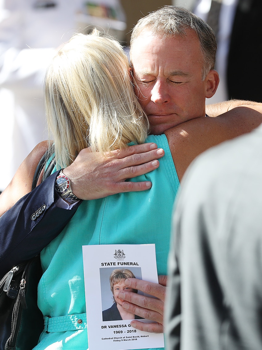 Will Hodgman is embraced outside the funeral of Vanessa Goodwin.