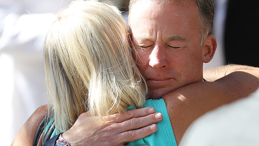 Will Hodgman is embraced outside the funeral of Vanessa Goodwin.