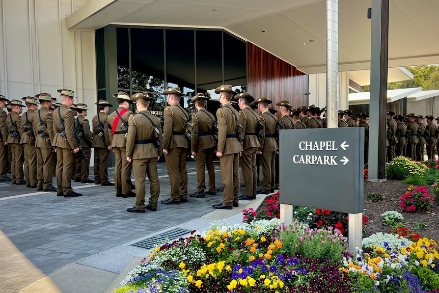 Australian soldiers stand outside the funeral of Lt Col Harry Smith 