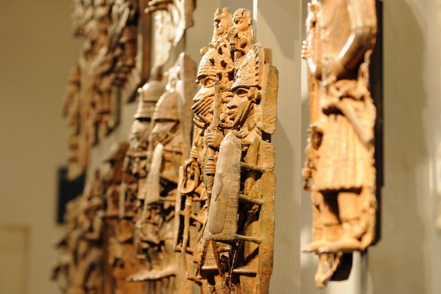 A side view of the sculptured figures on display in a row.