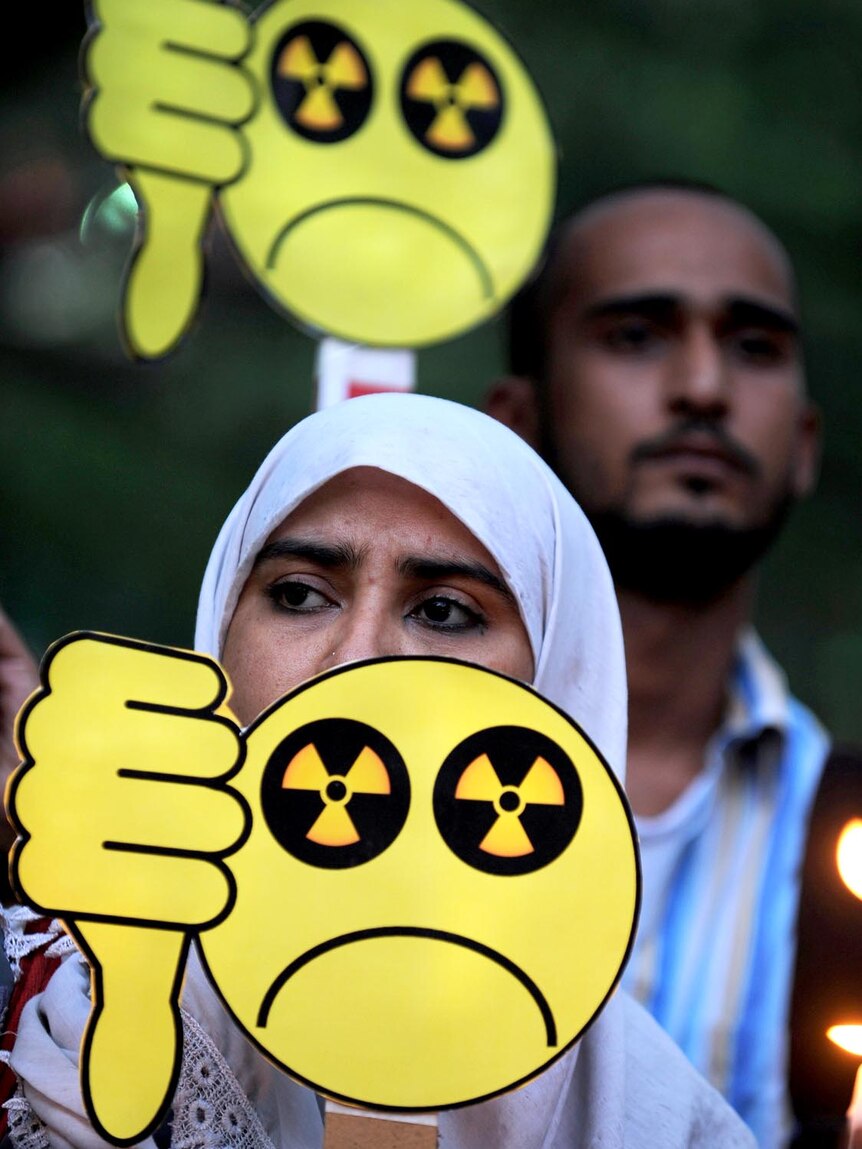 Indian social activists hold placards and candles during a protest against nuclear power.