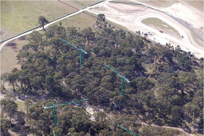 Aerial shot of cranes dotted on the landscape of a forest in western Sydney.