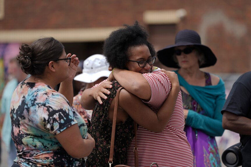Supporters embrace next to the spot where George Floyd was killed.