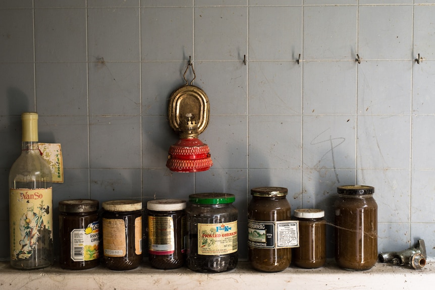 Jars covered in cob webs in the kitchen of an abandoned home