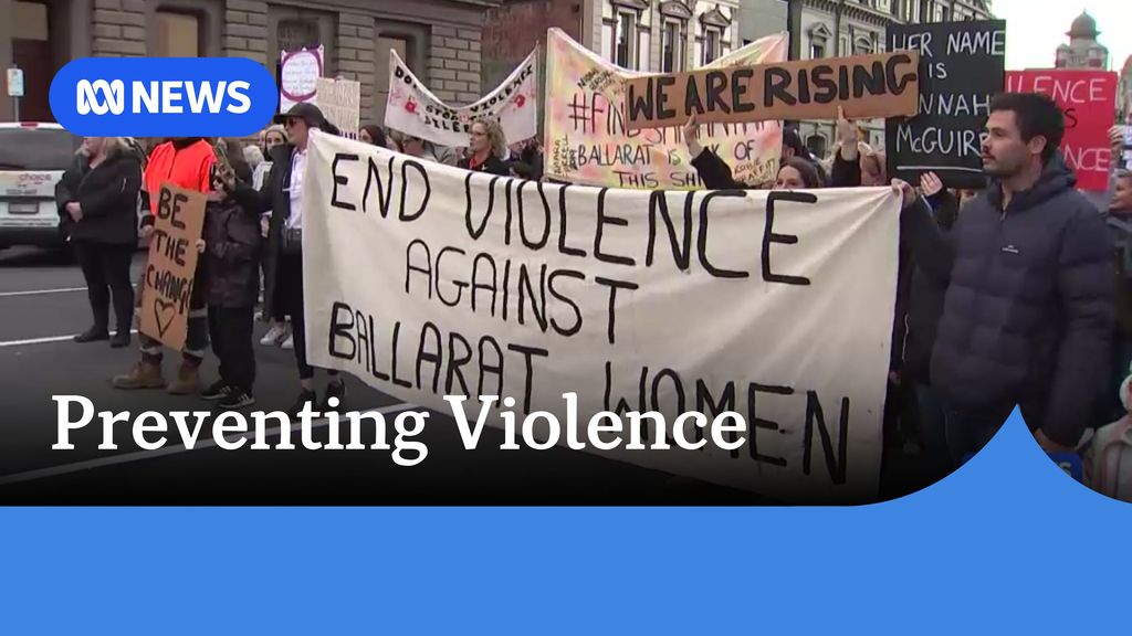 Preventing Violence: A man holds up a banner saying 'End Violence Against Ballarat Women' at the front of a protest march.