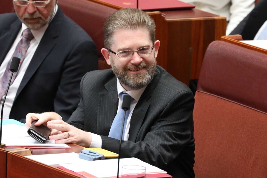 Liberal Senator Scott Ryan sitting in the senate looking pleased during the announcement that he is the new Senate President