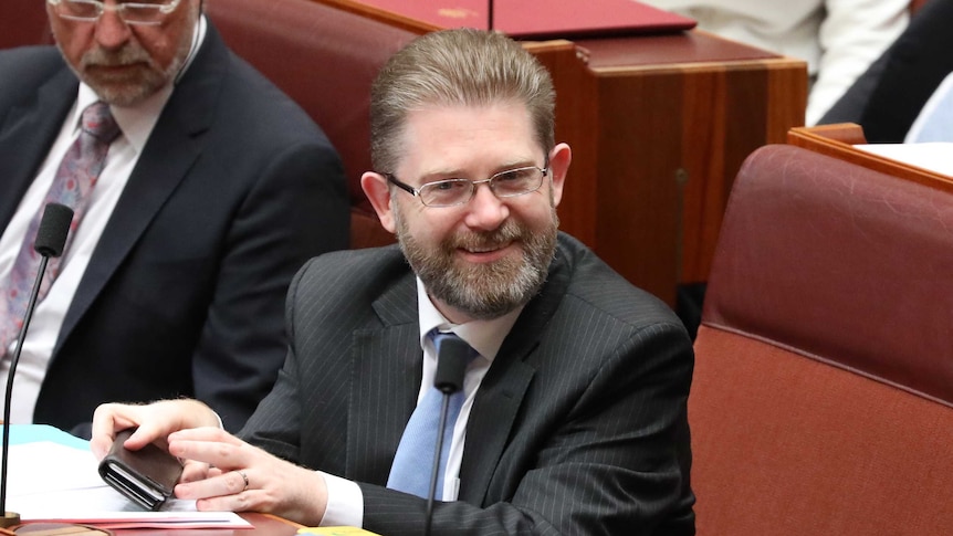 Liberal Senator Scott Ryan sitting in the senate looking pleased during the announcement that he is the new Senate President