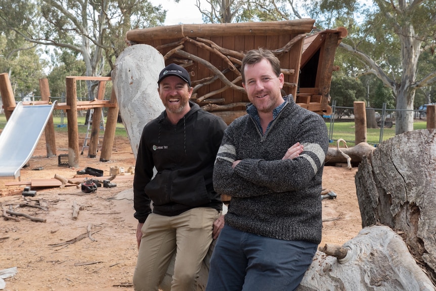 Simon Hutchinson and Peter Semple sit on a log at Morialta playground.