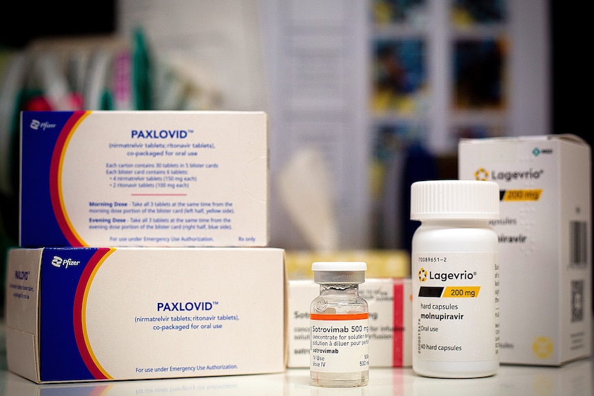 A generic image of three different drugs, packaged in boxes and small jars, which are used to treat COVID.
