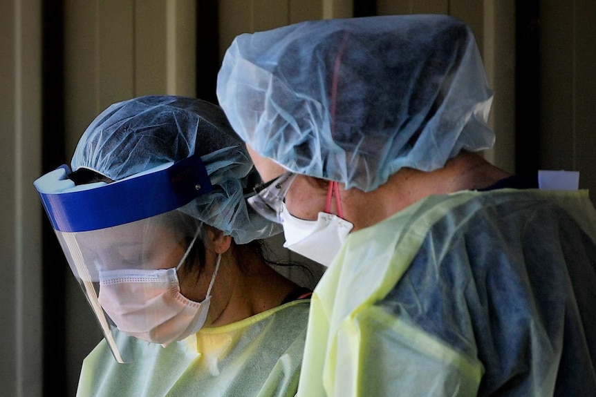 Hospital staff in PPE at a dedicated COVID-19 testing clinic.