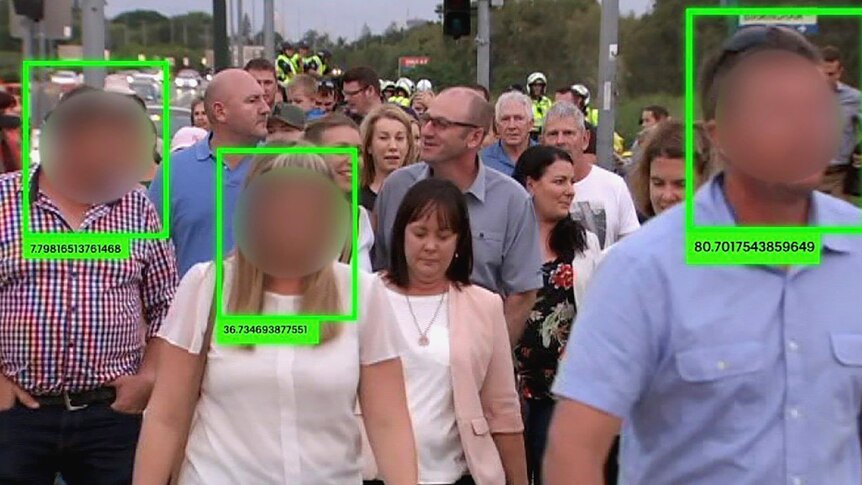 Blurred faces in a crowd with numbered green squares around them