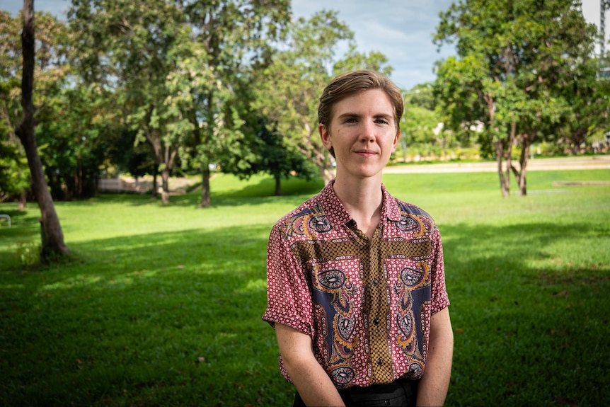 A young person stands in a park in Darwin.