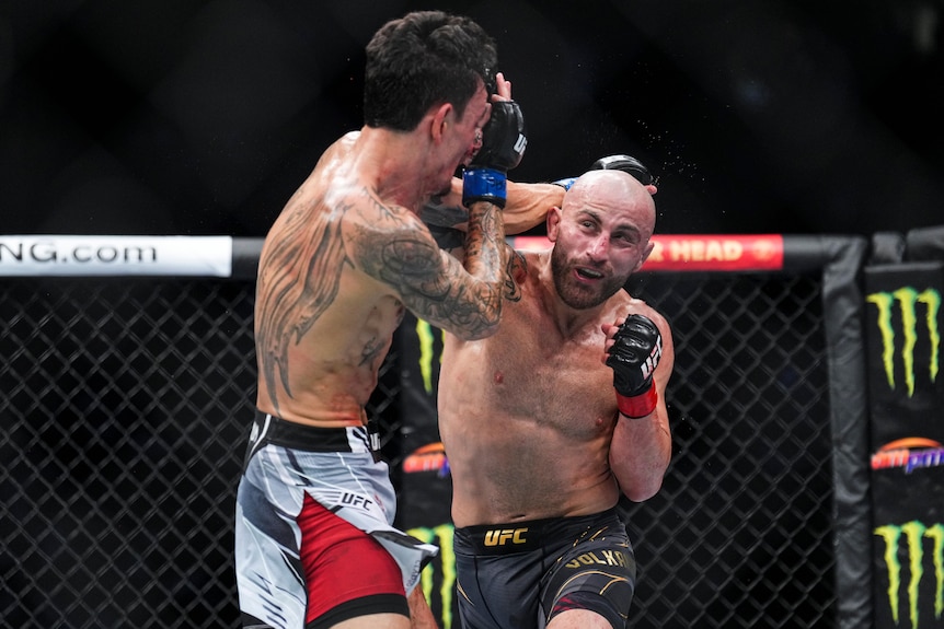 Alexander Volkanovski throws a punch towards the head of Max Holloway