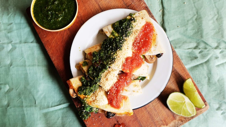 A plate of mushroom quesadillas covered in red and green salsa and lime crema to depict quick dinner recipe.