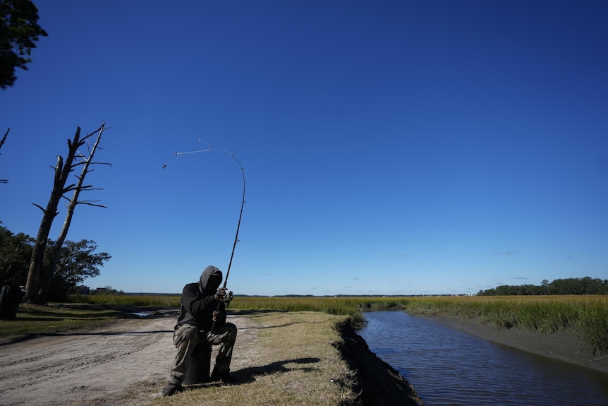 Hombre pescando lubina en Carolina del Sur.