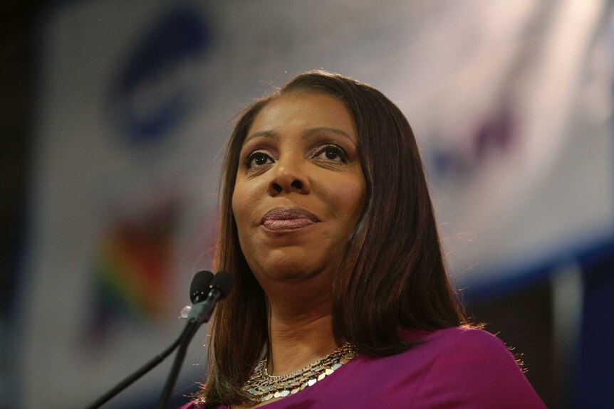 An African-American woman is photographed close-up at a lectern as she wears a purple top.