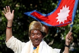 Man waves with Nepali flag.