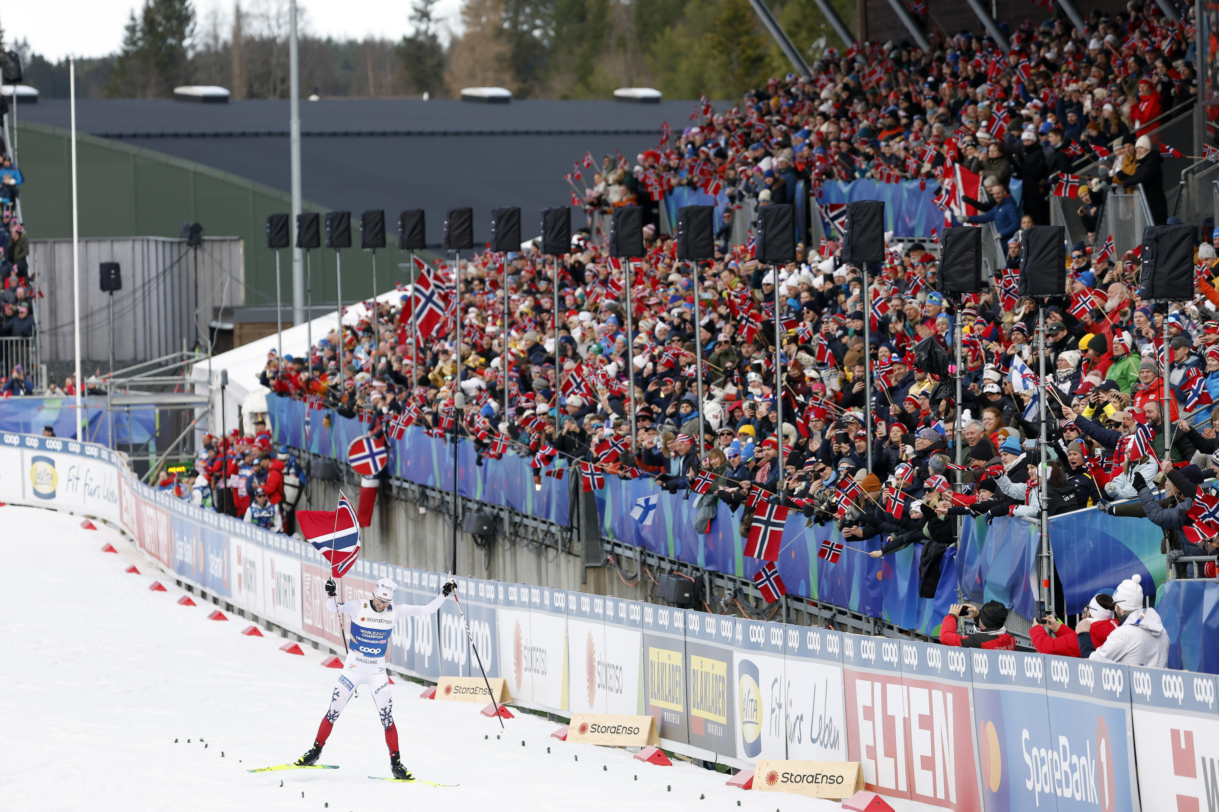 Jarl Magnus Riiber skis past a big crowd