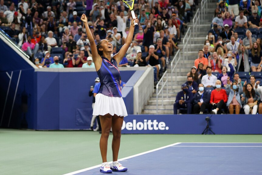 Leylah Fernandez holds her racquet in the air.