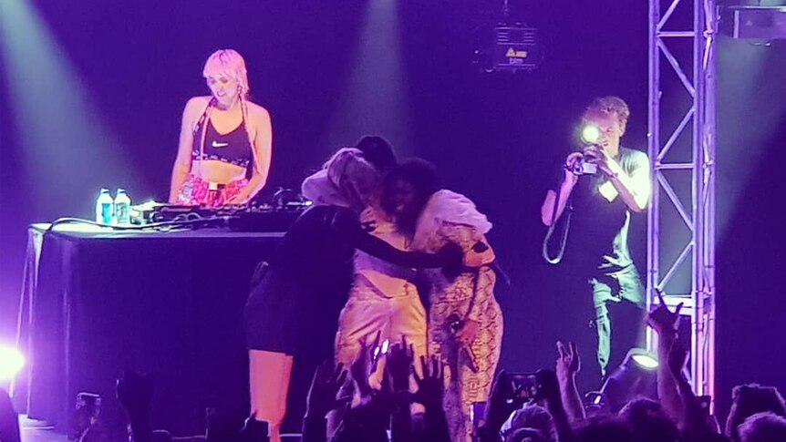 Charli XCX hugging Banoffee and Tkay Maidza on-stage at Sydney's Metro Theatre, October 2018