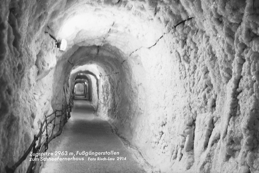 A black and white picture of an ice-coated tunnel carved into the rock