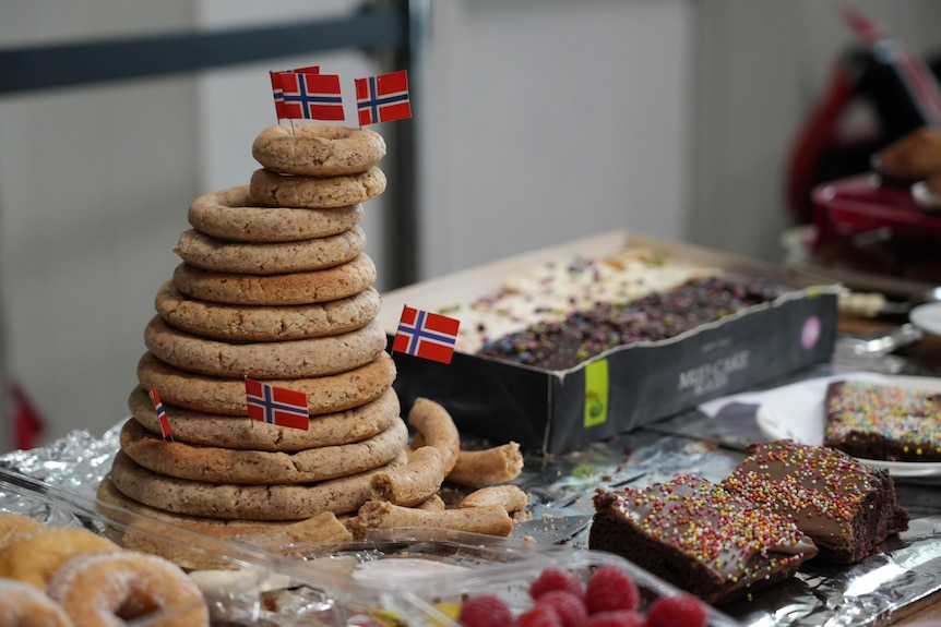 Traditional food topped with tiny Norwegian flags sit on a table.