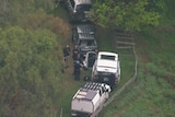 A shot of a rural property with police cars from above.