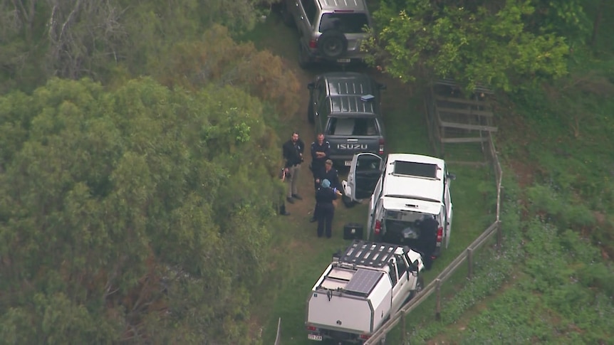 A shot of a rural property with police cars from above.