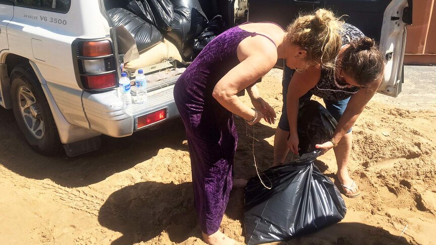 Locals pack their car full of sandbags in Rockhampton ahead of flood