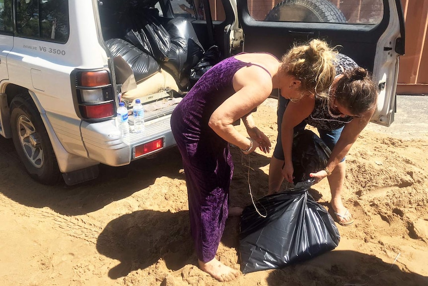 Locals pack their car full of sandbags in Rockhampton ahead of flood