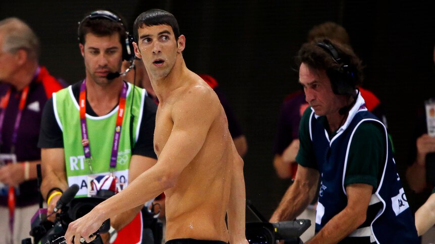 Michael Phelps leaves the pool deck after claiming silver in the men's 200m butterfly final.