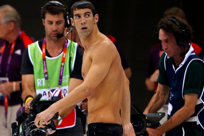 Michael Phelps leaves the pool deck after claiming silver in the men's 200m butterfly final.