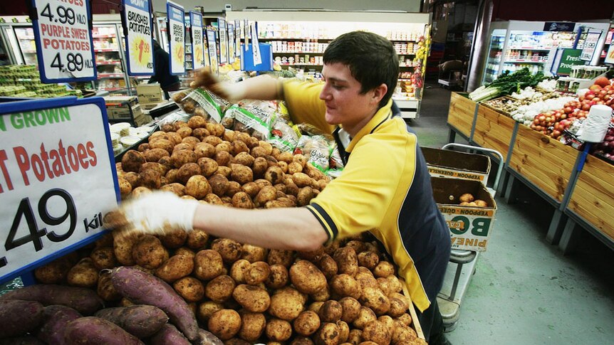 Man stacking supermarket shelf