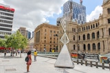 People stop to read about the large menorah standing in the Brisbane CBD.