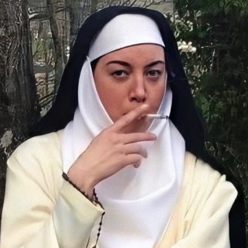 An image of a white woman dressed a nun in black and white robes smoking a cigarette.