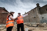 Fiona Parker and David Lloyd stand outside the old Sandhurst Gaol walls, amidst the construction zone