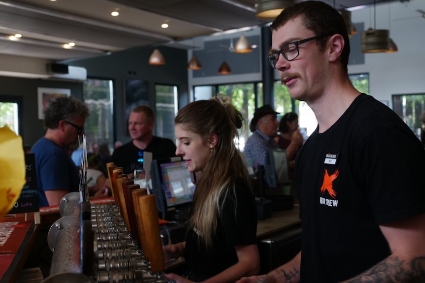 Two staff serving beer