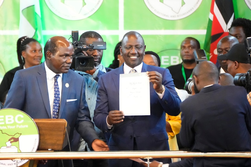 William Ruto, center, shows a certificate after the announcement of the results of the presidential race.