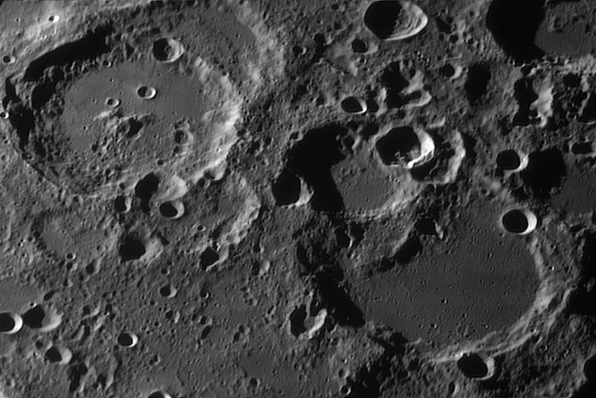 Craters appear on a dark gray surface.