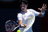 Bernard Tomic returns to Fernando Verdasco during their first round match at the Australian Open.