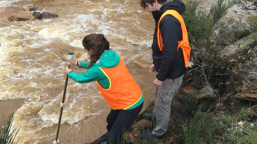 PhD students testing water at Mount Lyell, Tasmania.