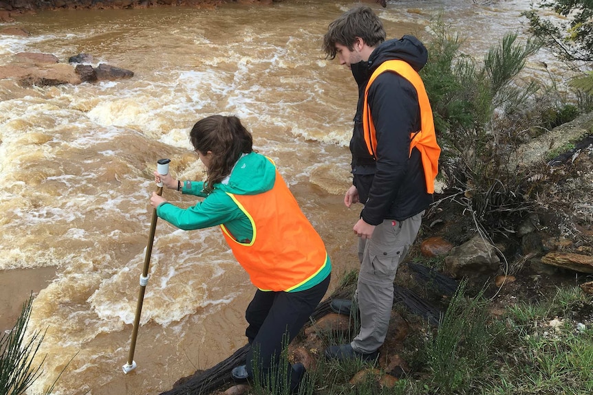 PhD students testing water at Mount Lyell, Tasmania.