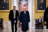 Two men walking in a senate building. 