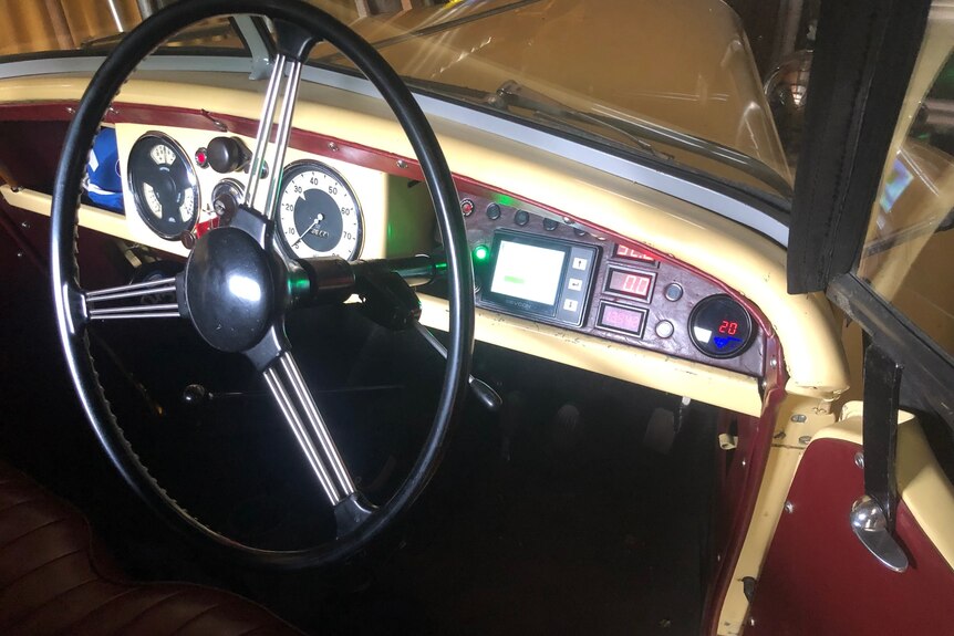 a classic car interior with a modified dashboard to accommodate new instruments