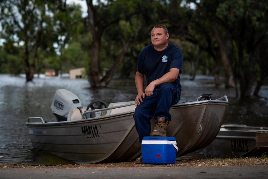 Riverland man Jason Fowler sits on a dinghy.