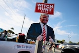 A sign says 'witch hunt' 