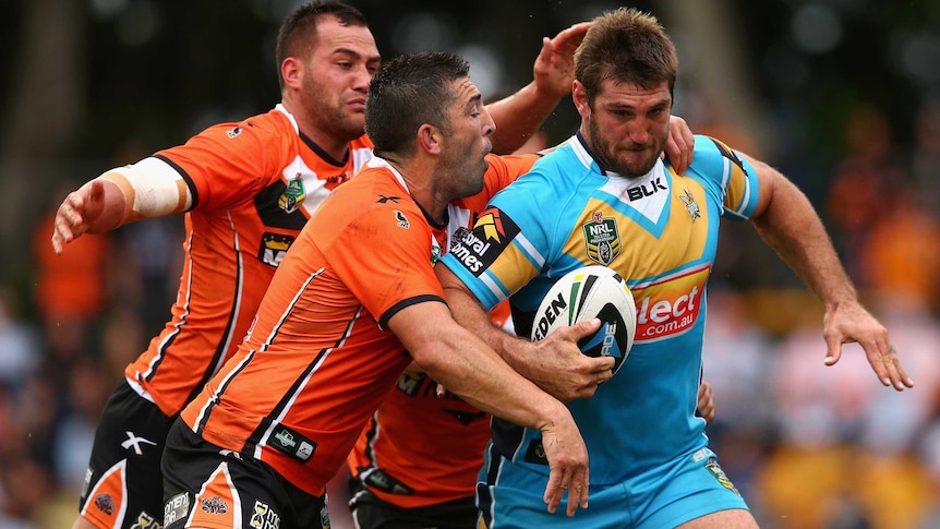 The Titans' Dave Taylor is tackled by the Wests Tigers' defence